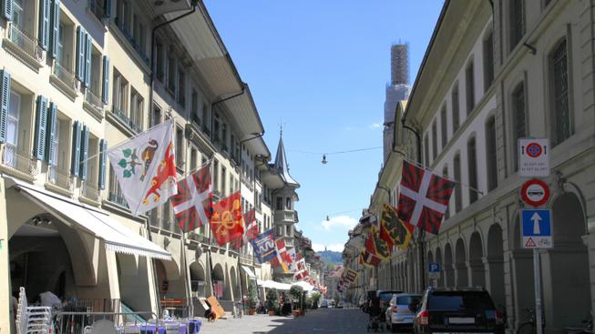 Stará ulice v centru Bernu s tradičními vlajkami