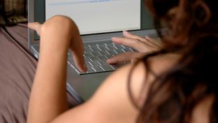 Dívka u počítače s webkamerou (ilustrační fotografie)