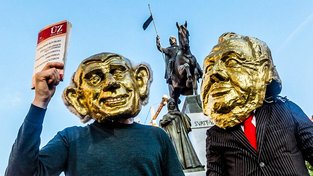 Demonstranti v maskách Babiše a Zemana během jarních protestů