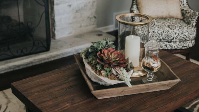 wooden-pot-wooden-table-with-flowers-candles-it-near-armchair-fireplace