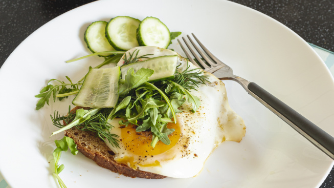 fried-eggs-with-cucumber-bread-black-table