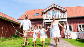 happy-family-running-meadow-front-house-front-yard-grass