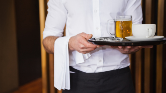smiling-waiter-holding-tray-with-coffee-cup-pint-beer