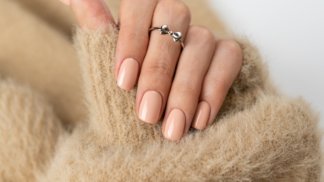 graceful-thin-fingers-girl-with-trendy-pastel-nude-manicure-fluffy-soft-sweater-cute-silver-ring-bow