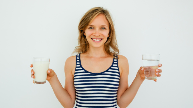 smiling-lady-holding-glasses-water-milk