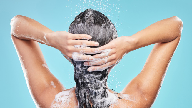 back-shower-woman-with-skincare-foam-hair-care-blue-studio-background-rear-view-person-model-with-water-drops-shampoo-cleaning-with-liquid-grooming-routine-wet-with-wellness