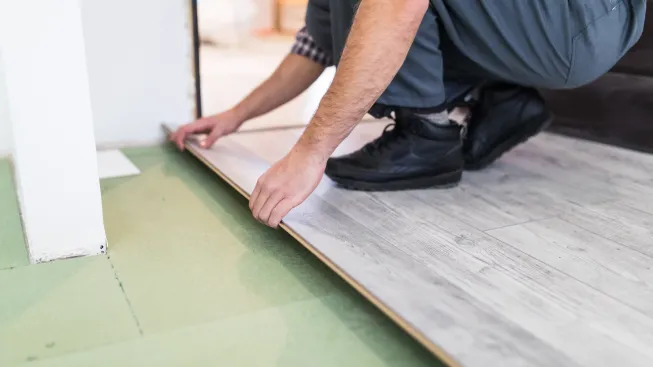 worker-processing-floor-with-laminated-flooring-boards